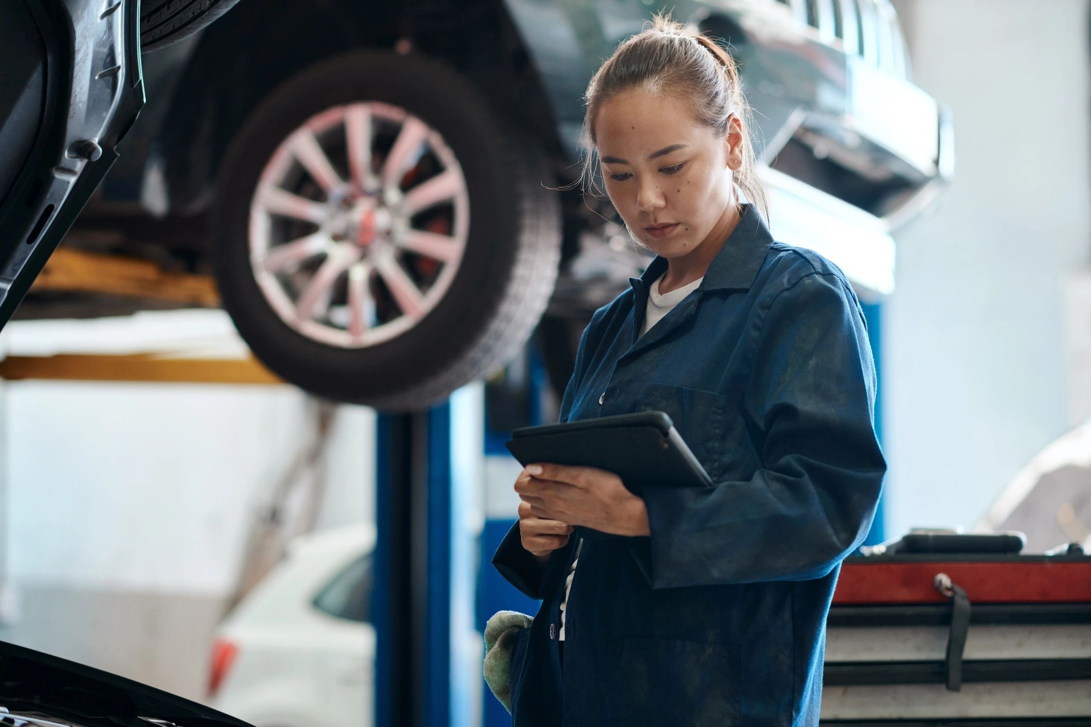 Mechanic holding a digital tablet in an auto repair shop