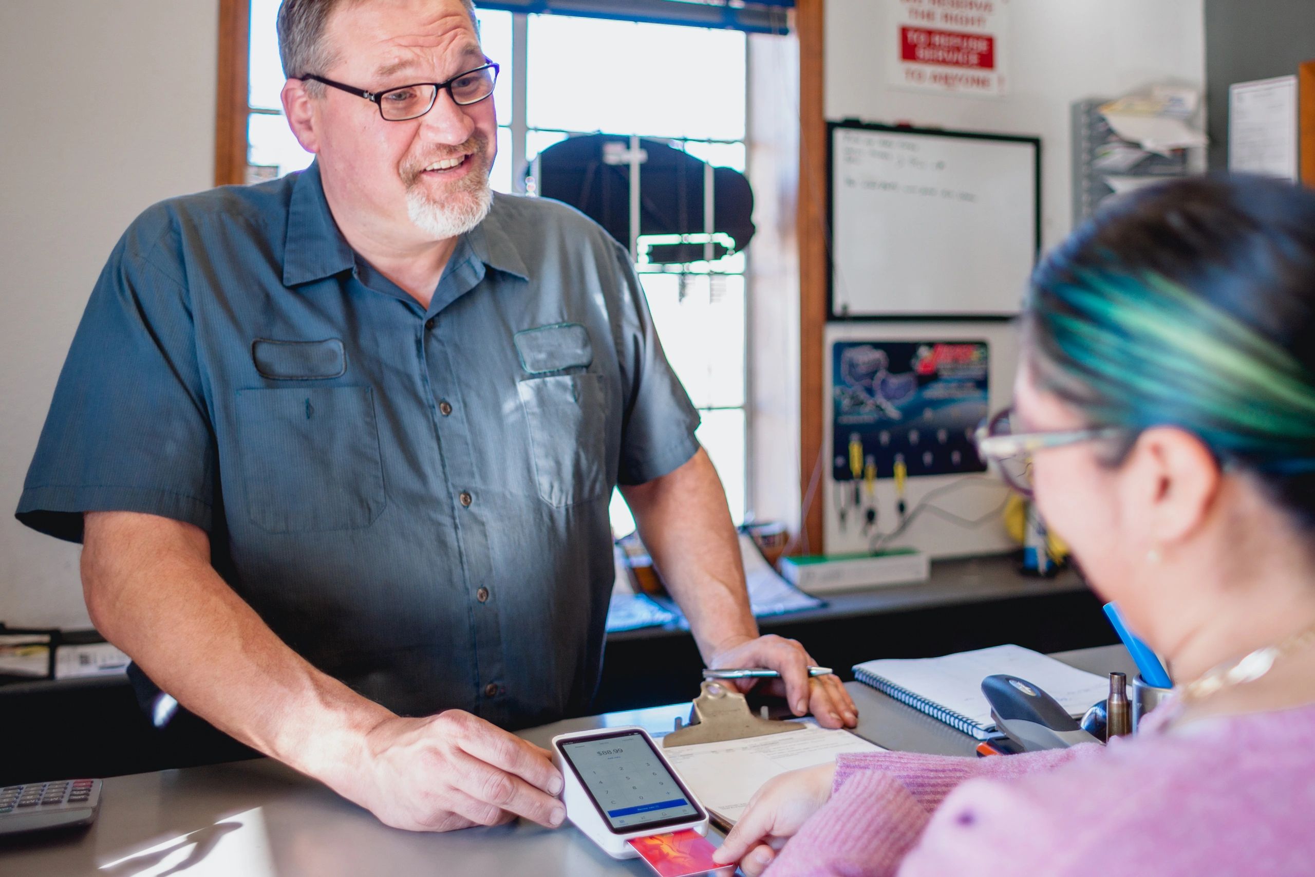 Mechanic discussing service details with a customer in a repair shop