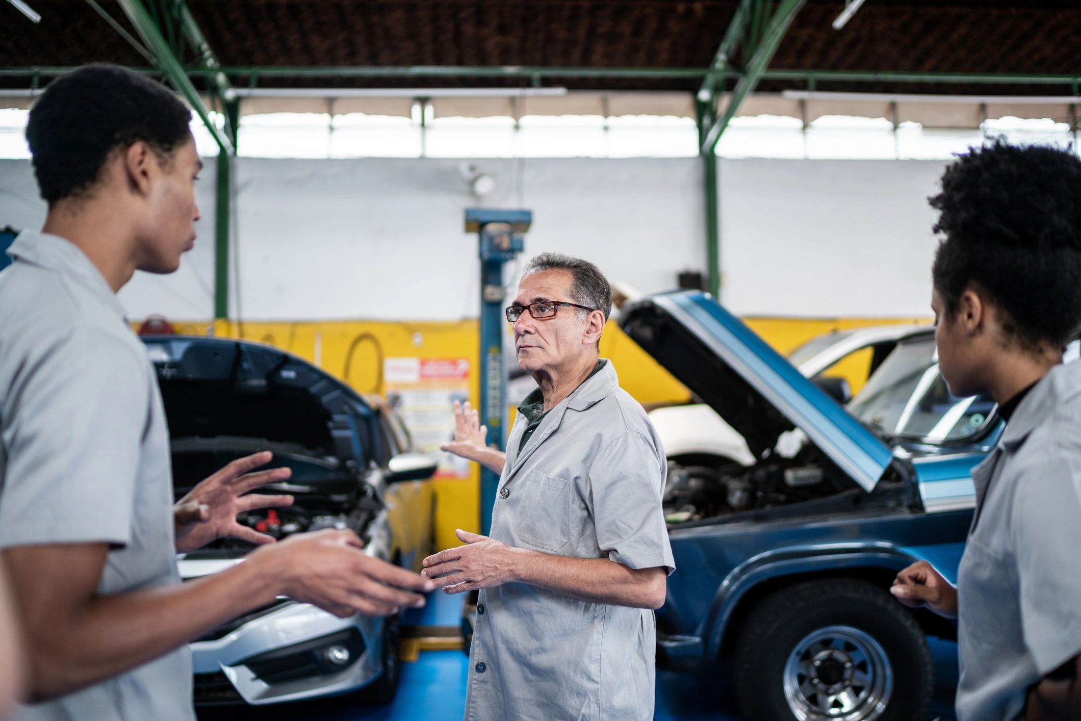 Mechanic and assistant reviewing vehicles in a repair shop