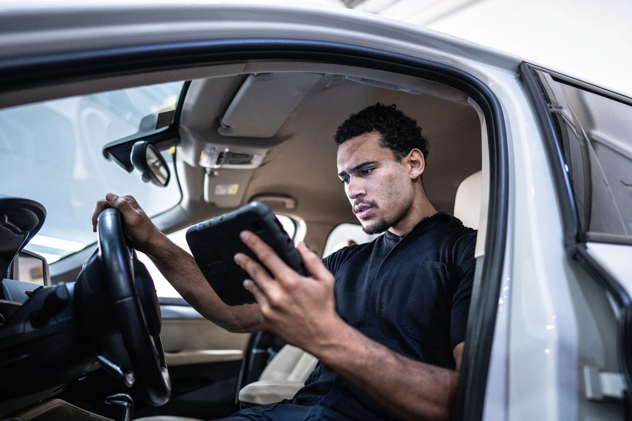 Mechanic using a tablet for vehicle diagnostics in a service bay
