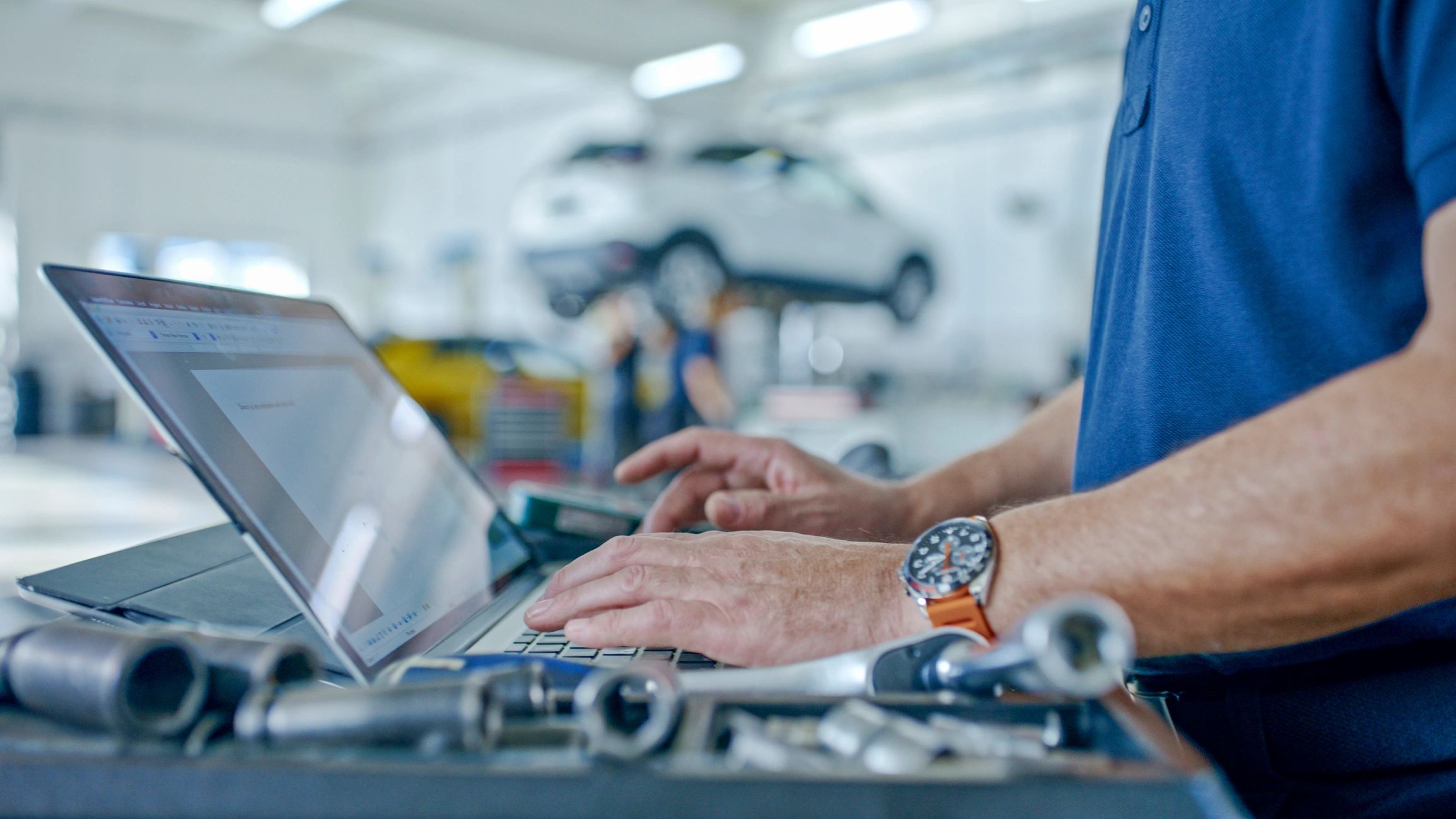 Service advisor using a laptop to schedule an auto repair appointment
