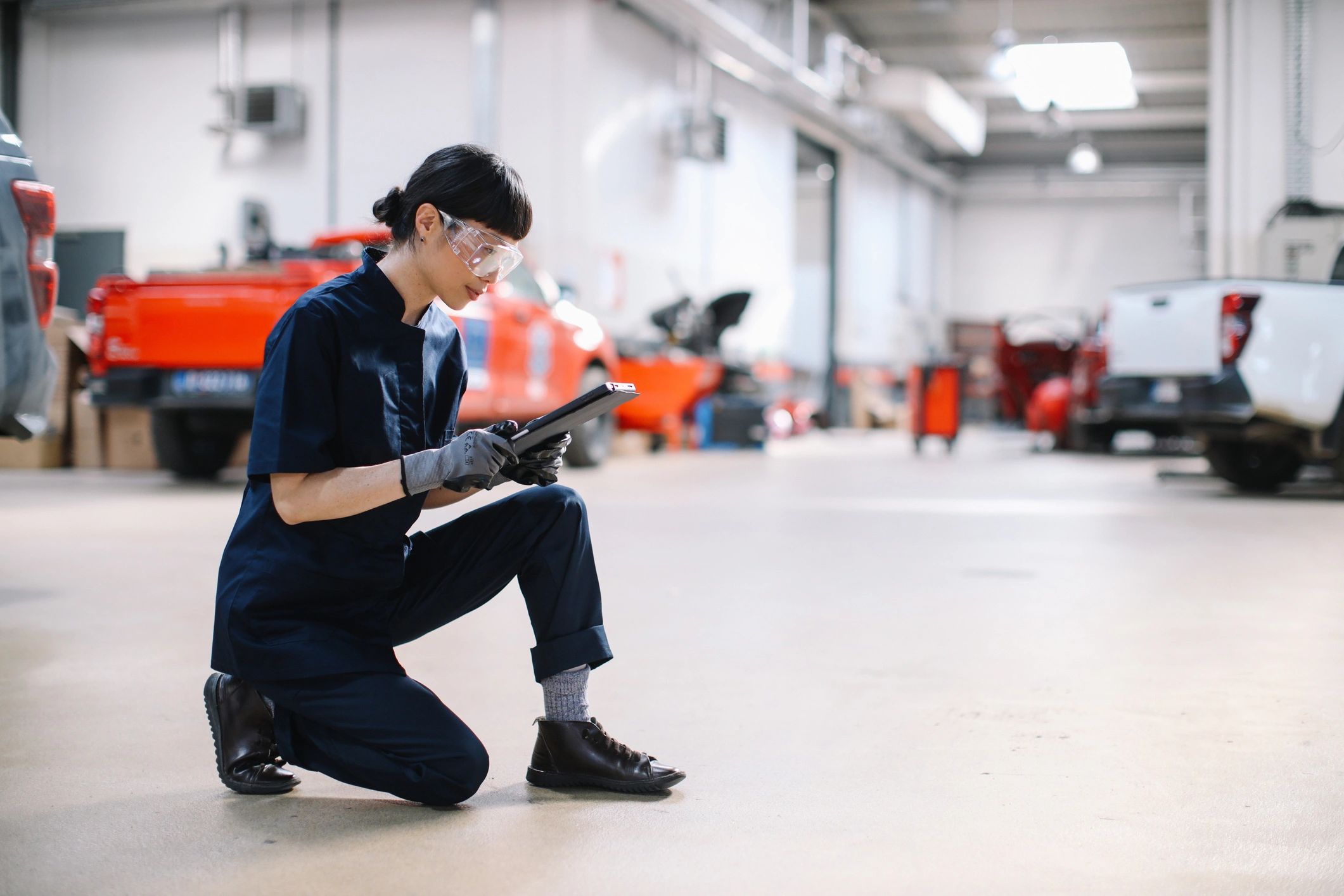 Technician inspecting a vehicle in a clean, modern garage