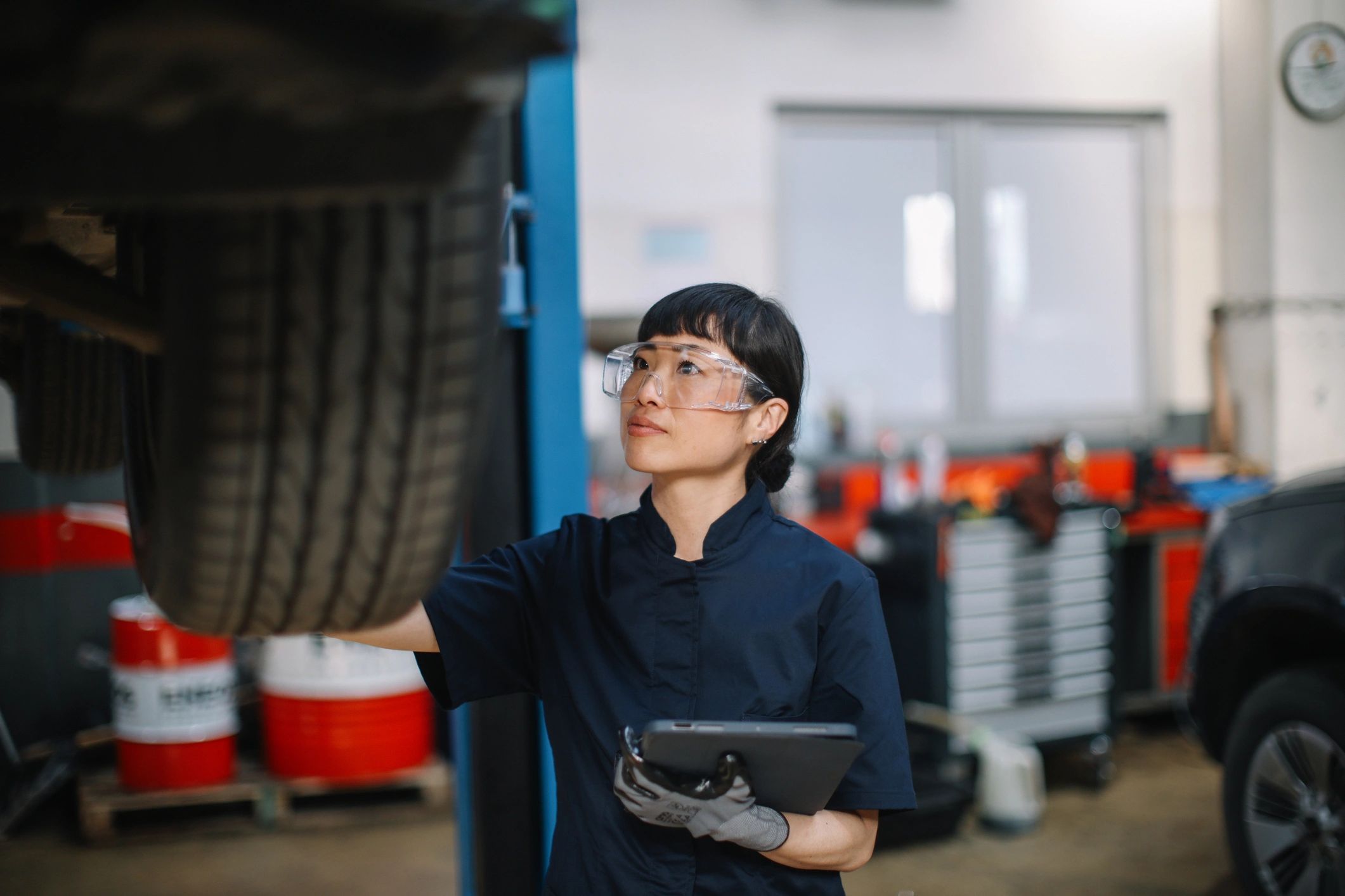 Technician performing a vehicle inspection in a modern auto shop